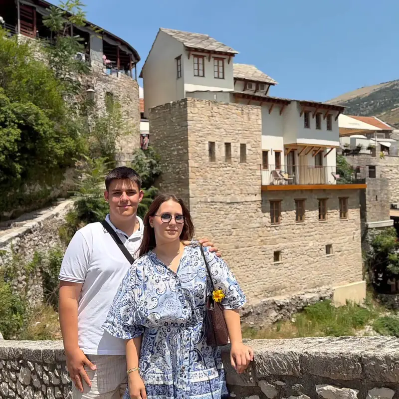 İki misafir Poçitel Köyü'nde taş kulenin önünde